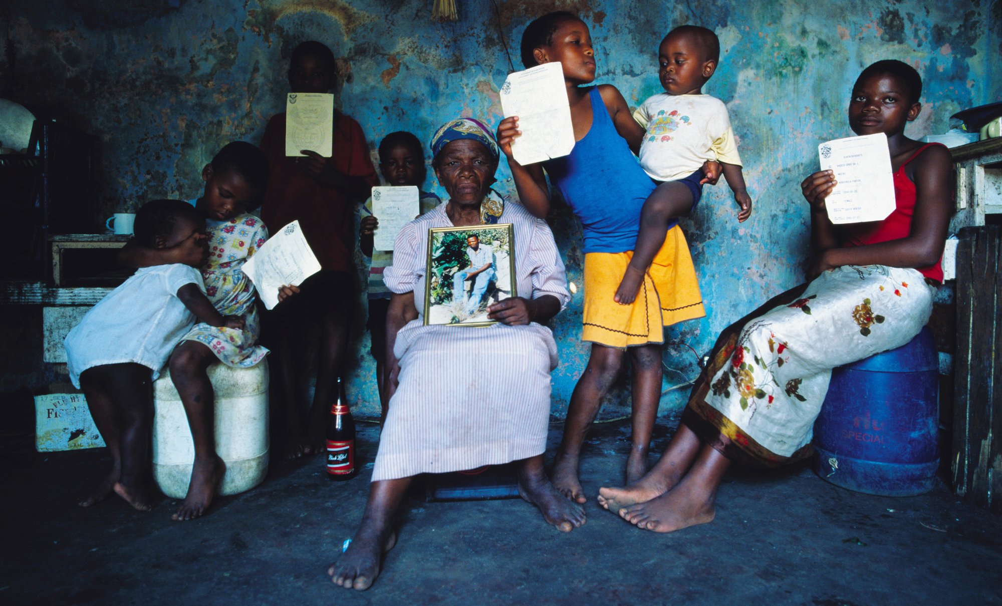 A grandmother in Richards Bay poses with her grandchildren she adopted after their parents died of AIDS. The children are holding death certificates of their parents.